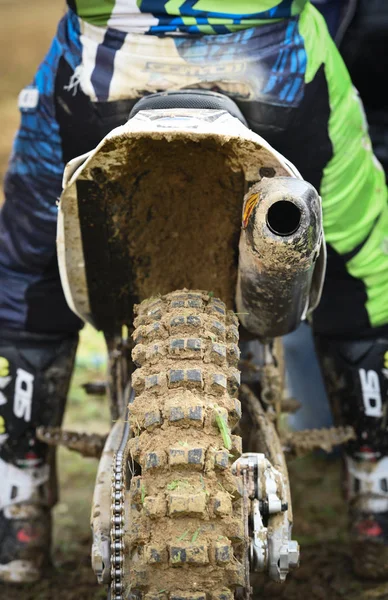 Athlete riding a sports motorbike and muddy wheel on a motocross