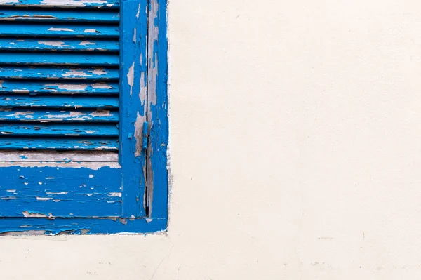 Janela fechada de madeira azul em uma parede branca — Fotografia de Stock