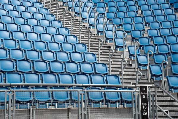 Cadeiras de estádio vazias de plástico azul em uma fileira — Fotografia de Stock
