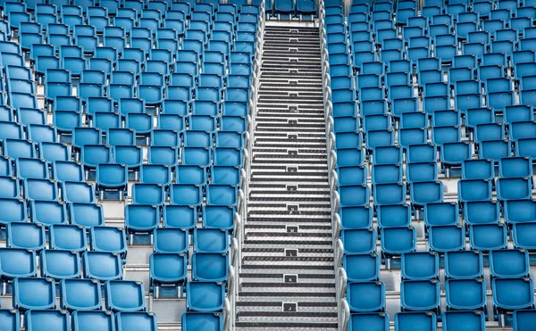 Cadeiras de estádio vazias de plástico azul em uma fileira — Fotografia de Stock