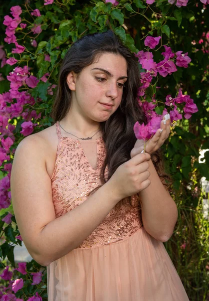 ピンクの咲く花を楽しむ魅力的な若い美しい女性 — ストック写真