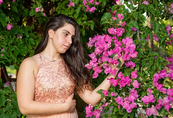 Přitažlivá Mladá krásná dáma, užívající růžovou kvetoucí květy — Stock fotografie