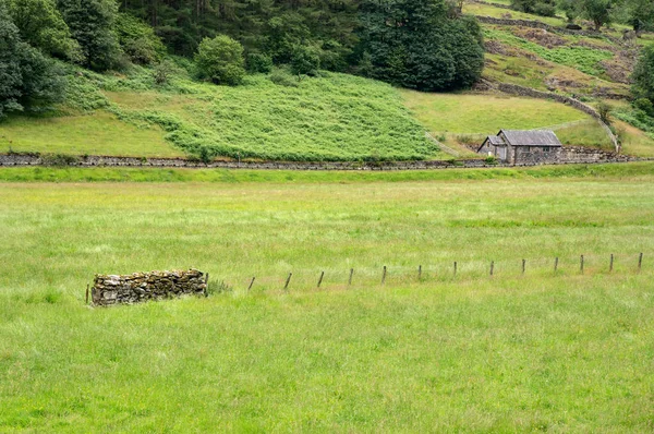 İngiltere'de Lake District pitoresk yeşil tarım arazileri üzerinde Ahşap yazlık ev — Stok fotoğraf