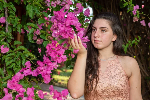 Atractiva joven hermosa dama, disfrutando de las flores rosadas en flor —  Fotos de Stock