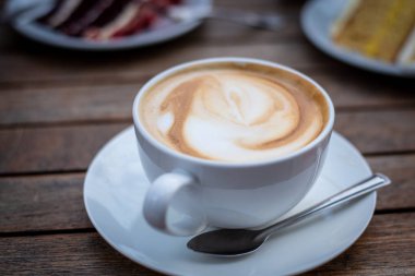 Taze aromatik kapuçino kahve ve lezzetli tatlı Fincan