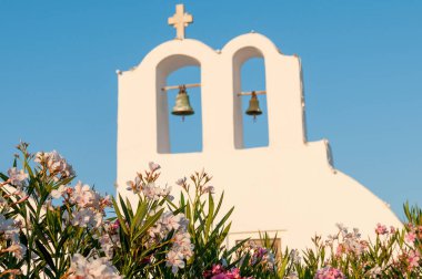 Mavi gökyüzüne karşı geleneksel beyaz Hıristiyan kilise çanı. Yunanistan 'daki Santorini adası