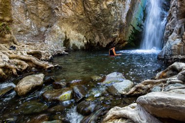 Millomeri şelalelerinin doğal havuzunda yüzen tanınmamış kadın Platres, Troodos, Kıbrıs