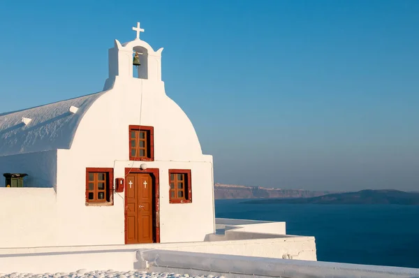 Weiße kleine Kirche bei Sonnenuntergang Oia Dorf Santorini griechische Insel in Griechenland — Stockfoto