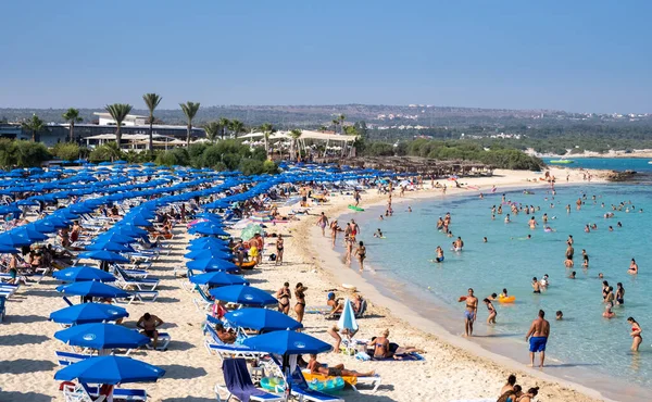 Idyllic beach with golden sand and turquoise water with tourists in summer — Stock Photo, Image