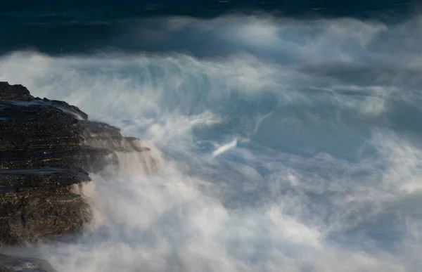 Espalhando ondas do mar tempestuosas e ventosas em uma costa rochosa — Fotografia de Stock