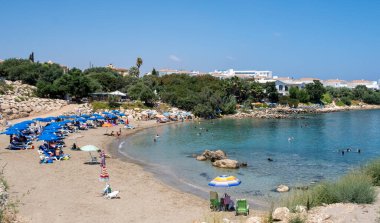 Turkuaz suyu ve yüzen turistlerle dolu bir sahil. Yaz Protaraları, Kıbrıs