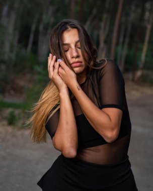 Genç, çağdaş dansçı ve koreograf ormanda dans ediyor. Çevrede dans eden kadınlar.