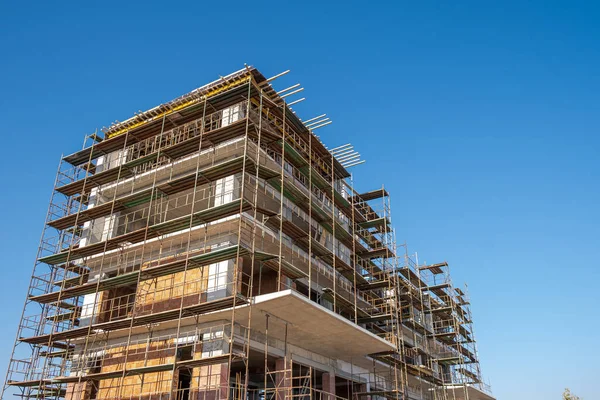 Chantier de construction de bâtiments résidentiels contre un ciel bleu clair — Photo