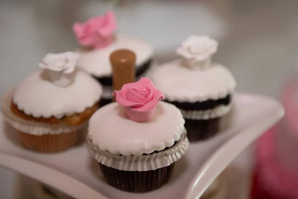 Pastelitos deliciosos frescos con guarnición de azúcar blanca y flor dulce rosa en la parte superior — Foto de Stock