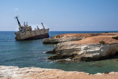 Okyanustaki kayalık bir sahilde terk edilmiş bir gemi. Peyia Paphos Kıbrıs