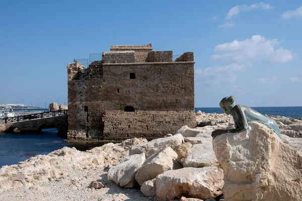 Bronzestatue einer Frau auf einem Stein mit Blick auf die Burg. Paphos Zypern — Stockfoto