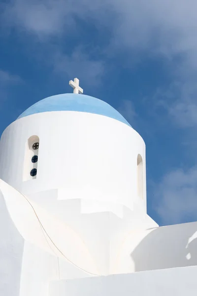 Christian church with belfry dome against blue cloudy sky.