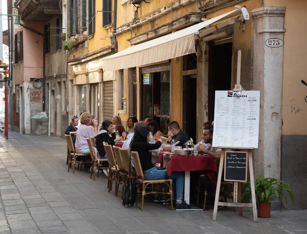 Touristen entspannen sich in einem Restaurant in den Straßen Venedigs in Italien. — Stockfoto