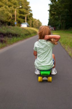 Bir kaykay üzerinde küçük kız