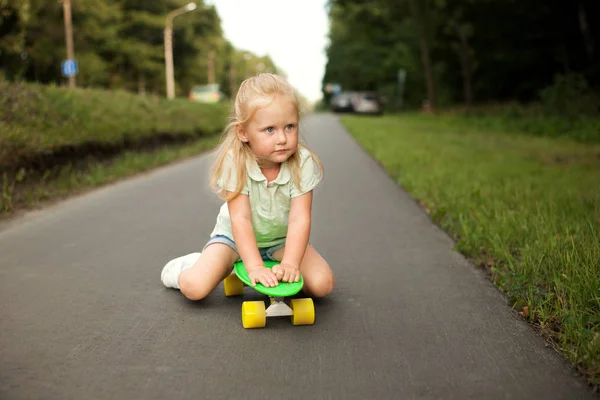 Küçük bir kız bir kaykay üzerinde sürme