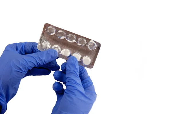 Beyaz bir arka plan üzerinde uyuşturucu. Elinde mavi eldiven yakın çekim.