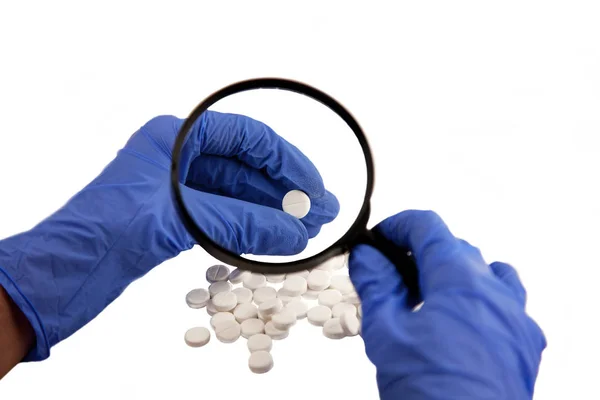 Beyaz bir arka plan üzerinde uyuşturucu. Elinde mavi eldiven.