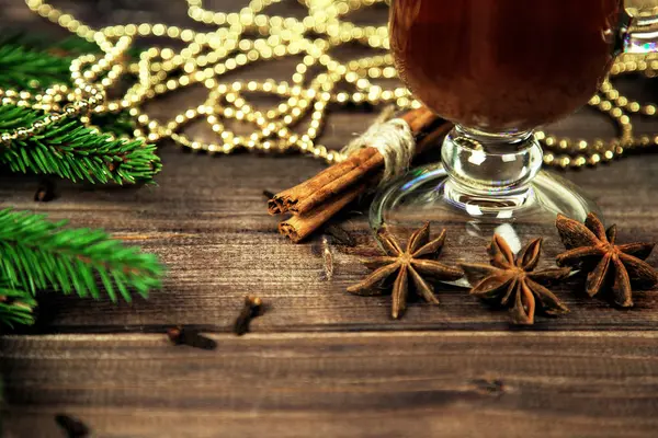 Baharatlı sıcak şarap ve ahşap arka planda Noel ağacı.