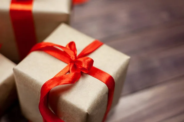 Noel hediye kutuları ve metin için yer ile ahşap masa üzerinde kırmızı kurdele