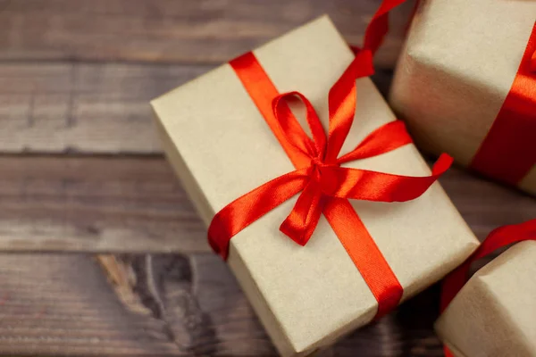 Noel hediye kutuları ve metin için yer ile ahşap masa üzerinde kırmızı kurdele