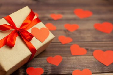 Kırmızı kurdele ve ahşap arka plan ve metin için yer kalpler hediye kutusu