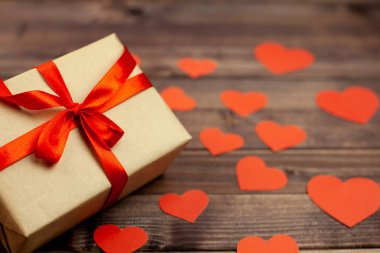 Kırmızı kurdele ve ahşap arka plan ve metin için yer kalpler hediye kutusu