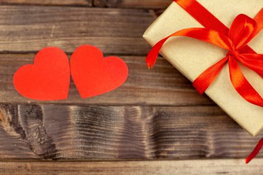 Sevgililer günü hediyesi. Hediye kutusu ahşap arka plan üzerinde kırmızı kurdele ile