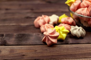 Çok renkli mini-meringues ahşap yüzey. Metin için yer.