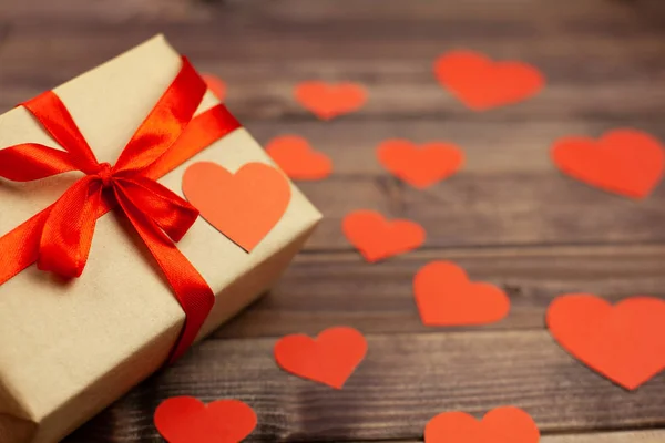 Kırmızı kurdele ve ahşap arka plan ve metin için yer kalpler hediye kutusu