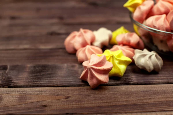 Çok renkli mini-meringues ahşap yüzey. Metin için yer.