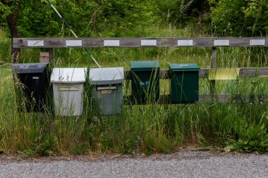 İsveç 'in kırsalında sakin bir yol boyunca duran ve yerel toplum yaşamını ve İskandinav kırsal cazibesini simgeleyen bir dizi farklı posta kutusu var..