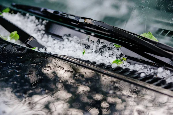 Large hail ice balls on car hood after heavy summer storm