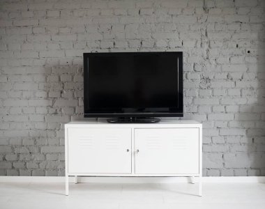 Modern düz lcd televizyon beyaz kabine ayarla. Gri tuğla duvar. Modern, aydınlık tavan daire.