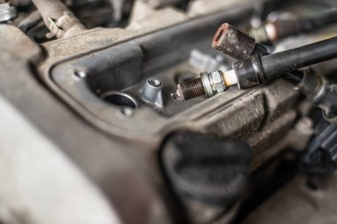 Mechanic changing broken car spark plugs. Car repair. Replacement of spark plugs clipart