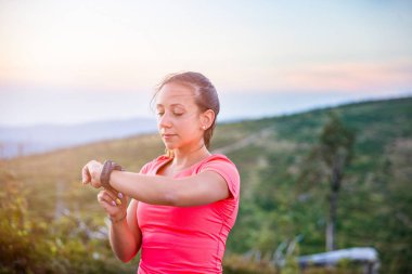 Kadın spor saati zamanında dağlarda çalıştıran iz sırasında kontrol. Szczyrk, Beskidy Mountains, Silesian Beskid, Polonya