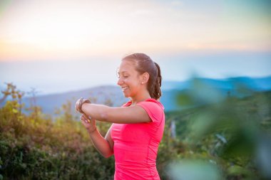 Kadın spor saati zamanında dağlarda çalıştıran iz sırasında kontrol. Szczyrk, Beskidy Mountains, Silesian Beskid, Polonya