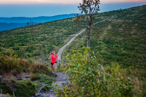 Woman trail running in mountains. Szczyrk, Beskidy Mountains, Silesian Beskid, Poland