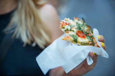 Kadın gitmek için İtalyan pizza yemek. Pizza parçalar halinde. Gıda götürün. Sokak gıda