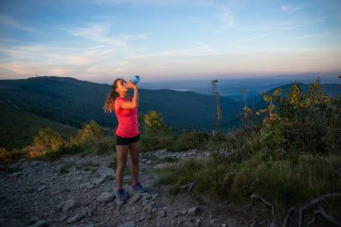 Kadın iz runner içme suyu dağlarda plastik şişe
