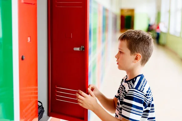 孩子男孩从金属学校的柜子里掏出衣服 儿童在学校 — 图库照片