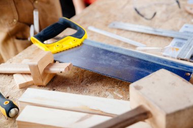 Carpenter'ın el testeresi ve ahşap masa üstünde alet. Yenileme, inşaat kavramı