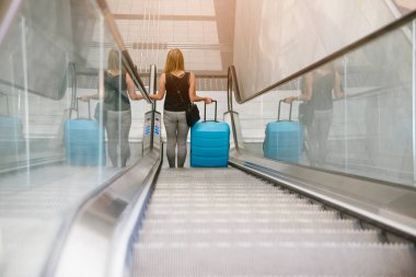 Arkadan görünüşü seyahat ve onun Bagaj yürüyen merdiven üzerinde Havaalanı üzerinde tutarak güzellik kadın ya da Tren İstasyonu