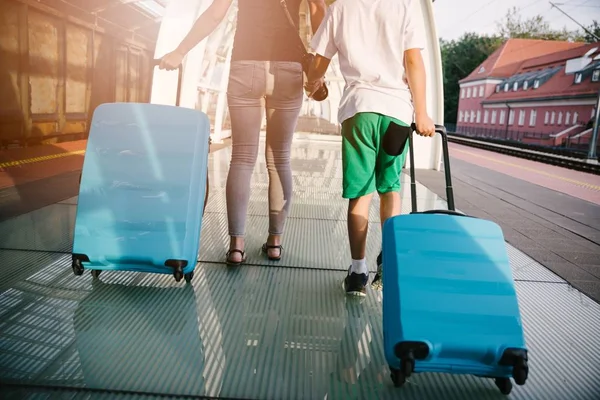 母と息子青い荷物スーツケース鉄道駅プラットホームで歩くと列車を待っていると — ストック写真
