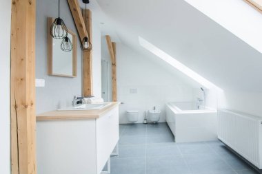 Gri duvarlar, ayna ve küvet ile parlak modern banyo. Tavan arasındaki modern parlak düz daire