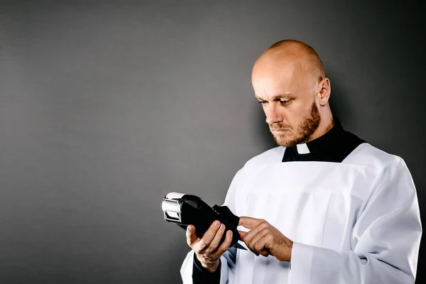 クレジット カードの端末持って白襟白冥衣と黒いシャツに司祭します 教会およびお金の概念 — ストック写真
